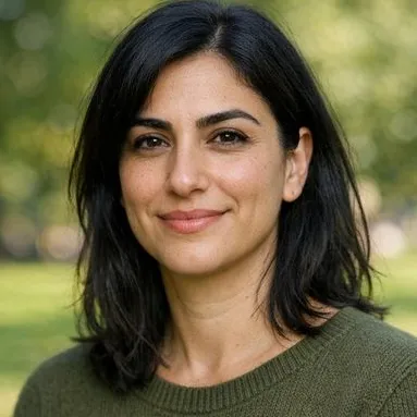 Woman in her late 30s, dark hair and olive skin, calm expression, knit sweater